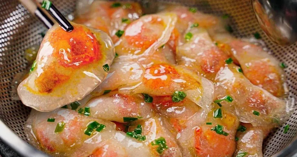 Người nội trợ đang gói bánh bột lọc với nhân tôm thịt