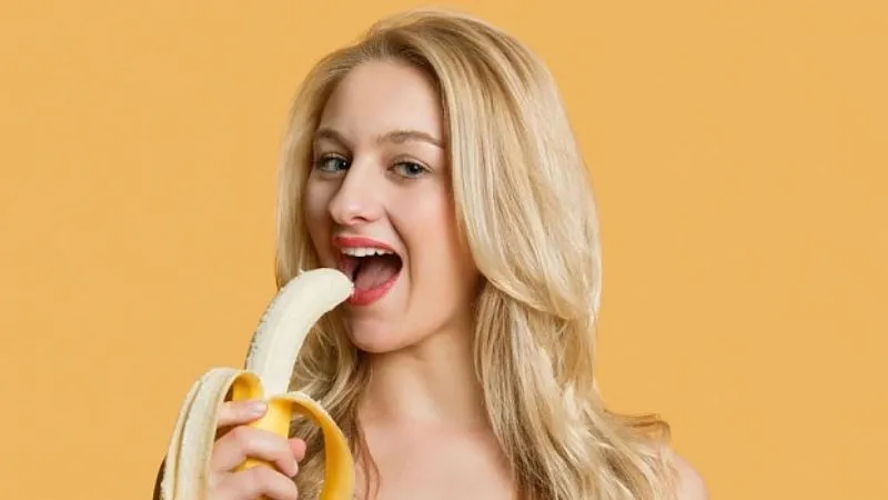 Một người đang bóc vỏ chuối, gợi ý về việc ăn chuối điều độ mỗi ngày