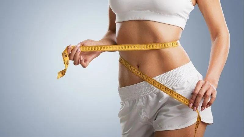 Người phụ nữ đang tập luyện và ăn chuối, minh họa lợi ích giảm cân
