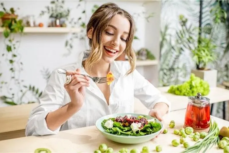 Người phụ nữ đang ăn cơm chậm rãi với bữa ăn cân đối