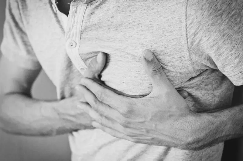 Người đàn ông cầm ly bia và lo lắng về tác động xấu đến sức khỏe tim mạch