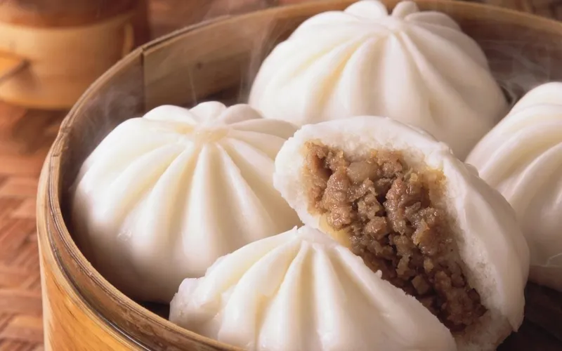 Một chiếc bánh bao đang được ăn kèm với rau xanh và các thực phẩm lành mạnh khác