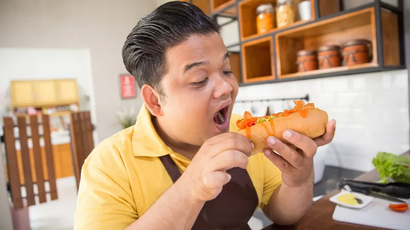 Người đang cầm bánh mì xúc xích, thể hiện việc tiêu thụ món ăn