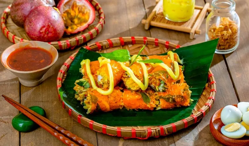 Một chiếc bánh tráng cuốn bơ với các loại topping như tép khô, hành phi và bò khô