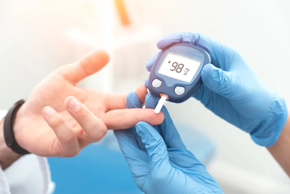 Hình ảnh một bệnh nhân đang đo đường huyết, minh họa việc rau dền giúp kiểm soát đường huyết
