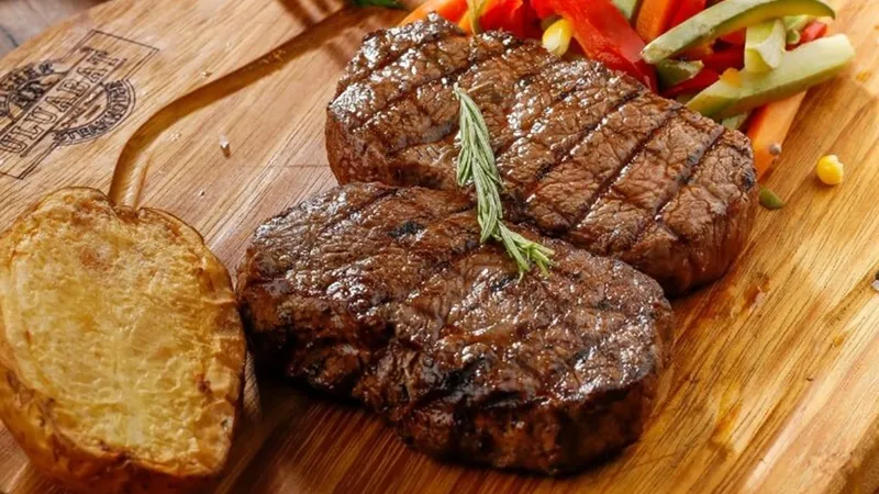 Miếng bò bít tết được cắt vuông góc với thớ thịt, tẩm ướp muối, dầu và bơ
