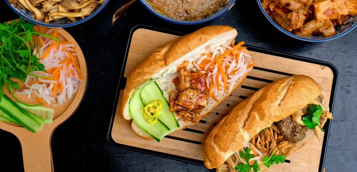 Một ổ bánh mì chay với nhiều loại rau củ và topping thực vật