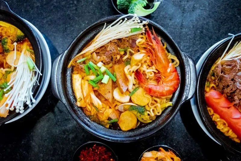 Người phụ nữ mang thai đang chạm tay vào bụng, suy nghĩ về việc ăn mì cay