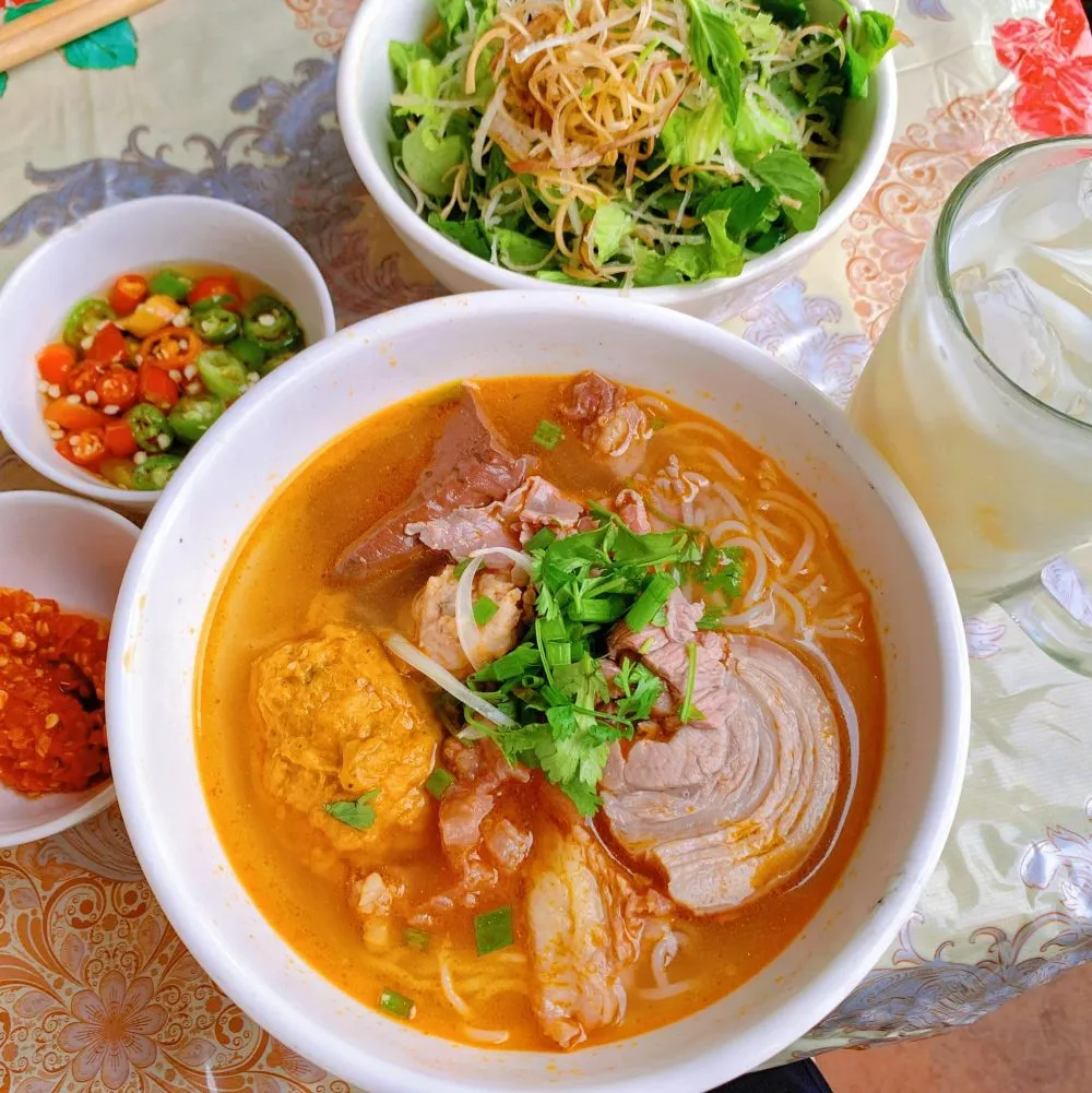 Một tô bún bò giò heo đầy đặn, hấp dẫn với màu sắc rực rỡ