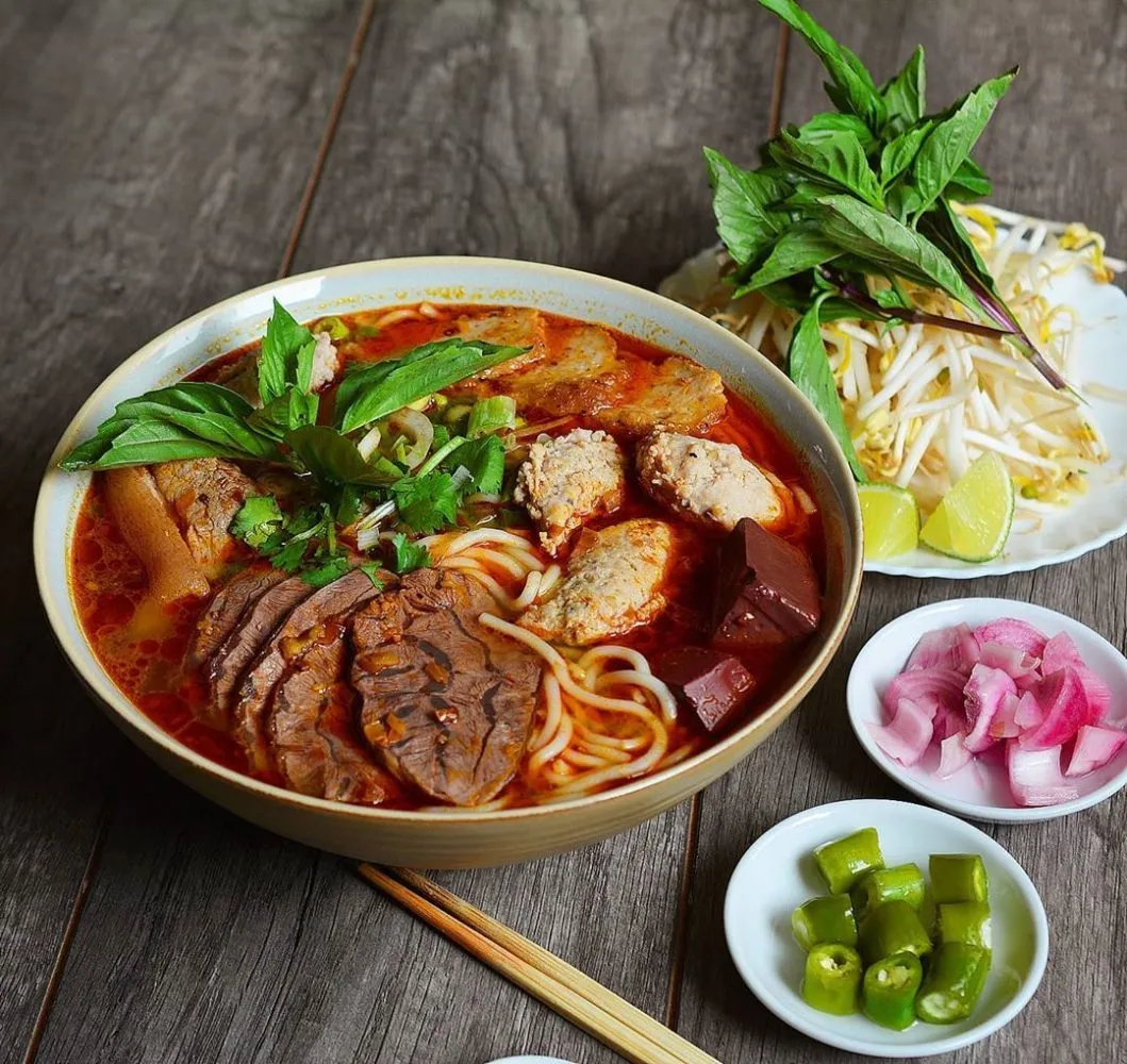 Một tô bún bò nóng hổi với đầy đủ thịt bò, chả, tiết và rau ăn kèm