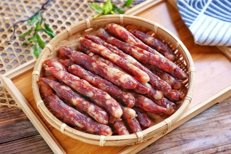 Lạp xưởng thái khoanh và một quả trứng chiên vàng ươm trên đĩa, minh họa bữa ăn sáng