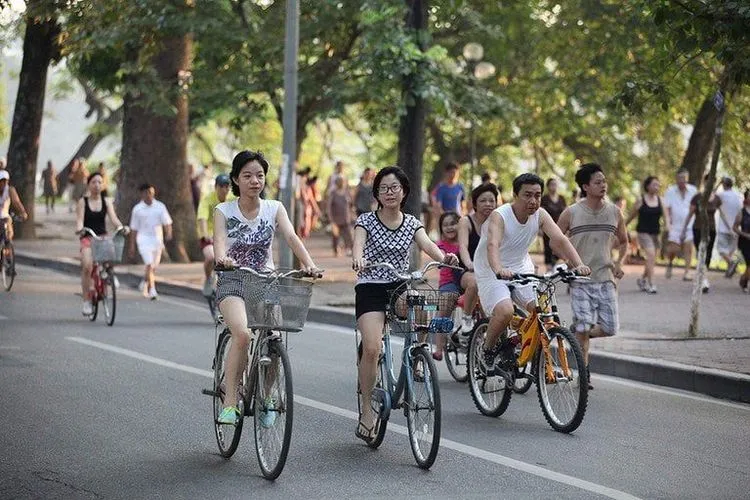 Người đạp xe đạp thể dục trên đường dưới ánh nắng