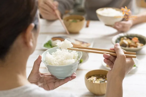Hình ảnh một gia đình đang quây quần bên mâm cơm ấm cúng, vui vẻ trò chuyện