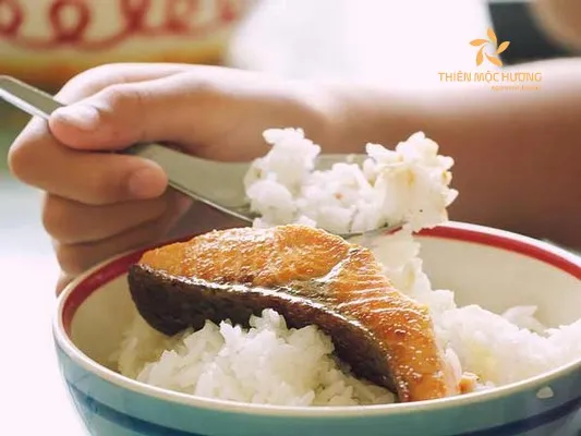 Hình ảnh một tô cơm trắng ăn kèm với món cá kho, gợi nhắc về bữa ăn dân dã, bổ dưỡng