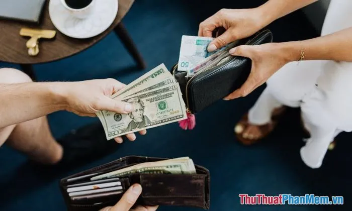 Hai người phụ nữ đang ngồi cà phê trò chuyện vui vẻ, một người tặng tiền cho người kia