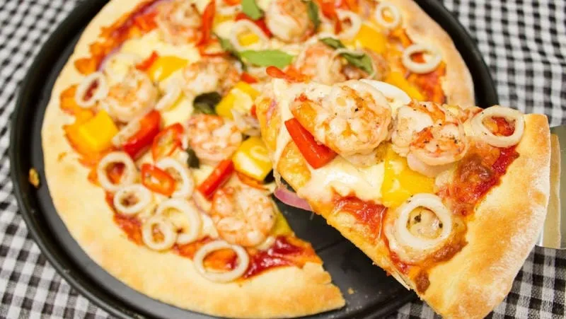 Một miếng pizza hải sản tươi ngon, hấp dẫn với tôm và mực