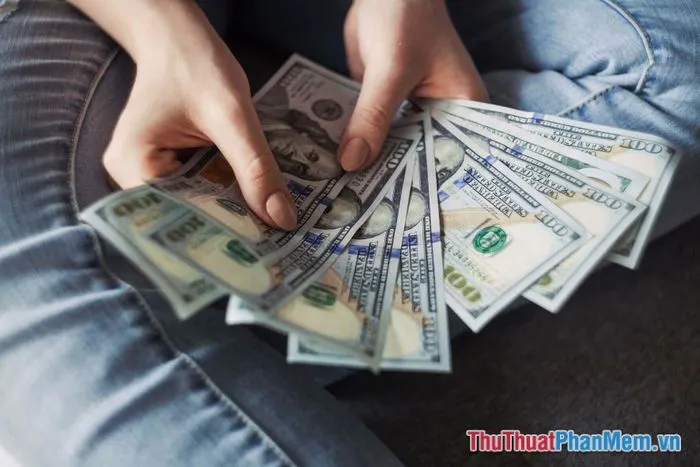 Người chồng đang nhẹ nhàng đặt một tờ tiền vào tay người vợ, cả hai đều mỉm cười