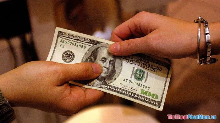 Một người đang hào phóng trao những tờ tiền đô la Mỹ cho người khác
