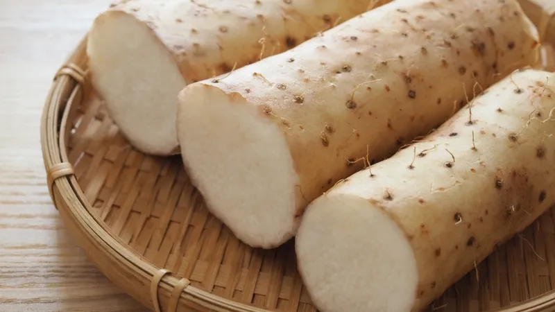 Củ khoai từ nguyên vẹn với lớp vỏ nâu, đặt trên nền mộc
