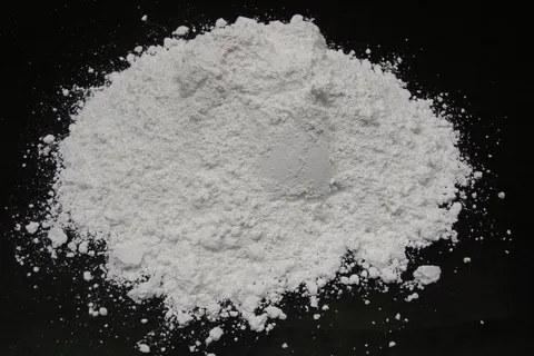 Người nông dân đang phun vôi bột lên cây trồng trong vườn để bảo vệ cây khỏi bệnh tật