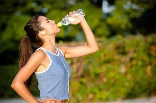 Cốc nước lọc đặt cạnh lát chanh tươi, tượng trưng cho thói quen uống nước lành mạnh