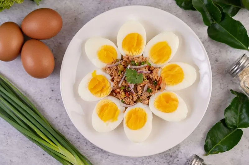 Một giỏ trứng gà tươi được sắp xếp gọn gàng trên bàn bếp, đại diện cho khẩu phần ăn trứng hợp lý