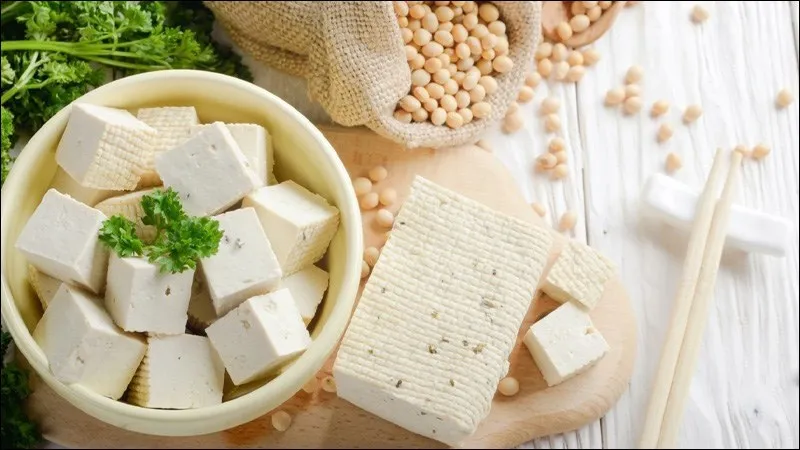 Hình ảnh một người đàn ông và một phụ nữ đang suy nghĩ, kèm theo dấu hỏi chấm, biểu thị sự cân nhắc khi ăn đậu phụ