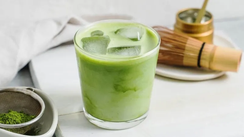 Một ly trà sữa Thái xanh đang được rót từ bình pha