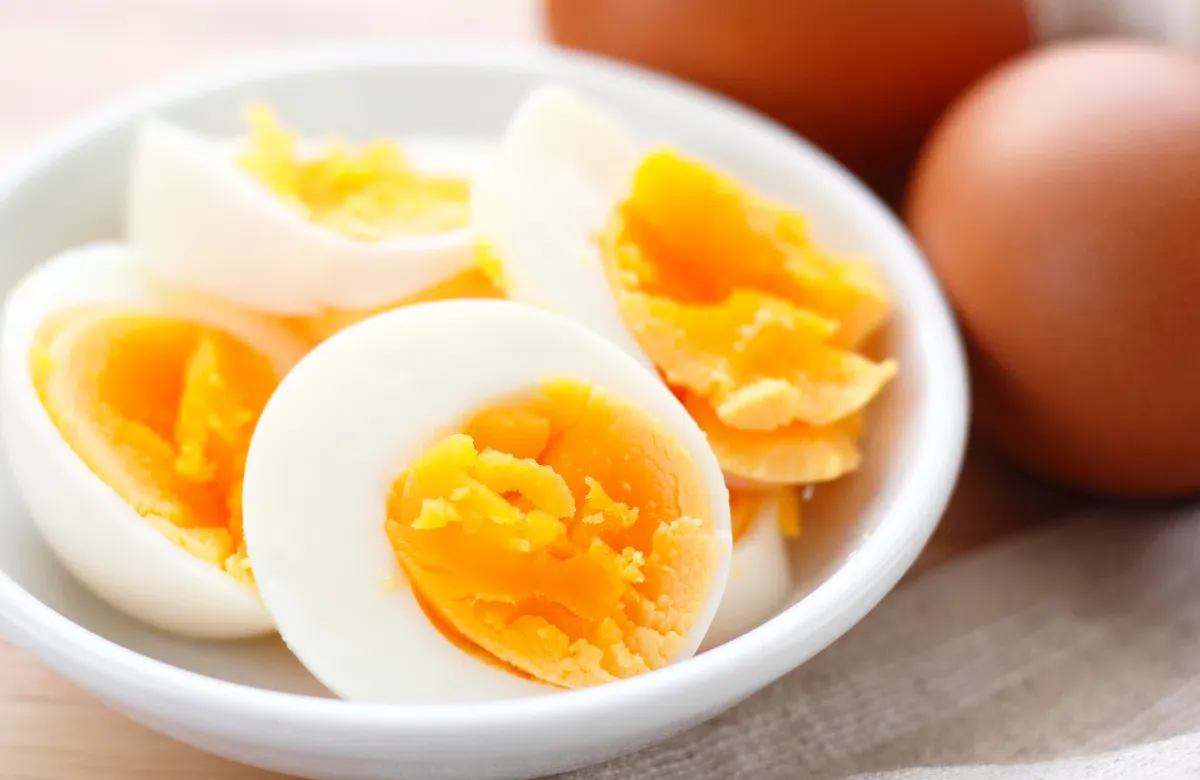 Một quả trứng gà luộc chín tới, vỏ đã bóc một phần