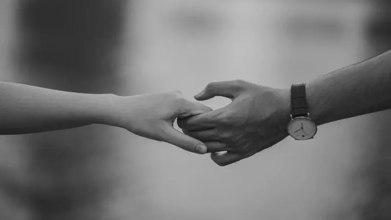 Một cô gái khẽ chạm tay vào vai chàng trai khi trò chuyện, tạo cảm giác thân mật